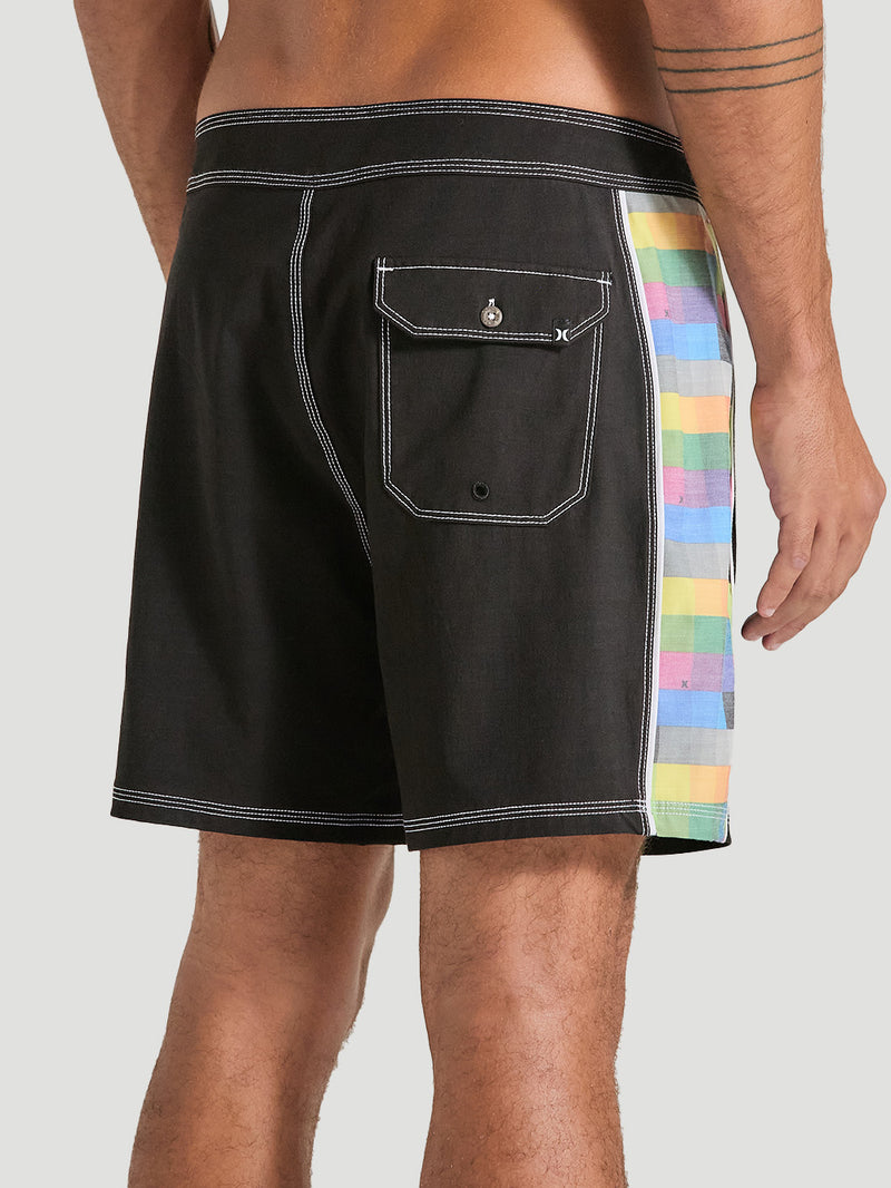 Homem usando boardshorts phantom 16 polegadas preto com detalhe lateral em estampa xadrez colorida. A peça possui bolso traseiro com aba e costura contrastante.