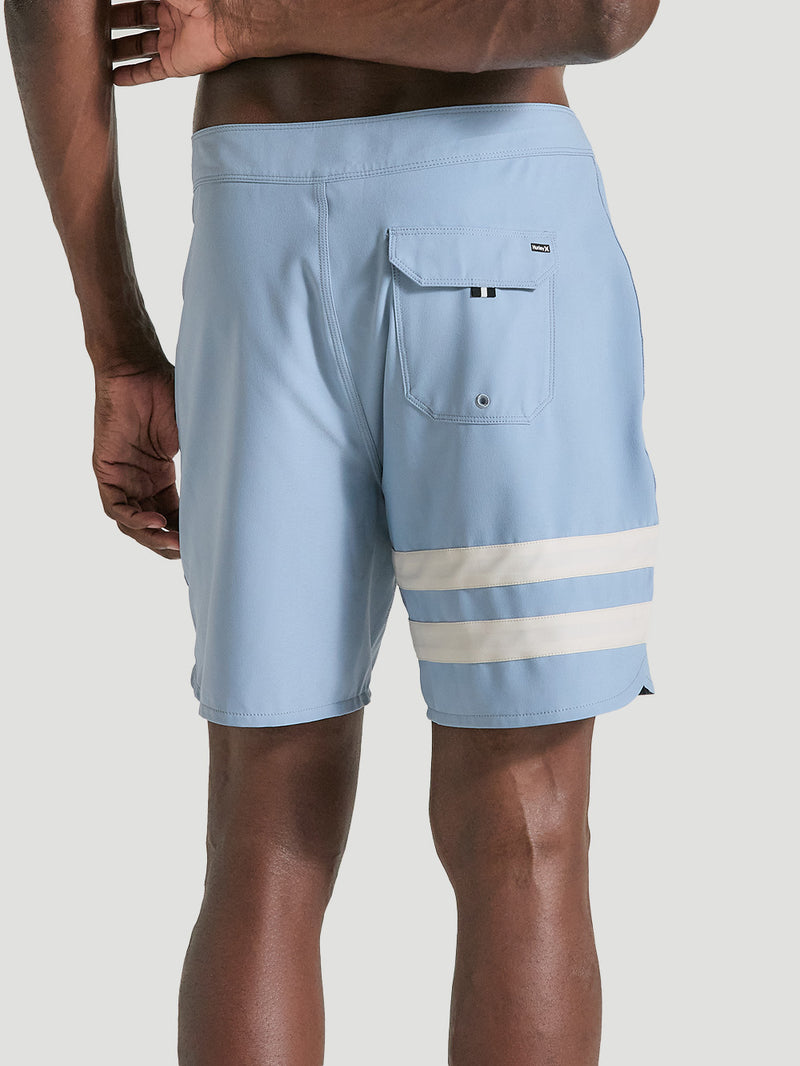 Homem vestindo boardshorts phantom 18 polegadas azul, com listras brancas horizontais na perna esquerda e bolso traseiro com aba.