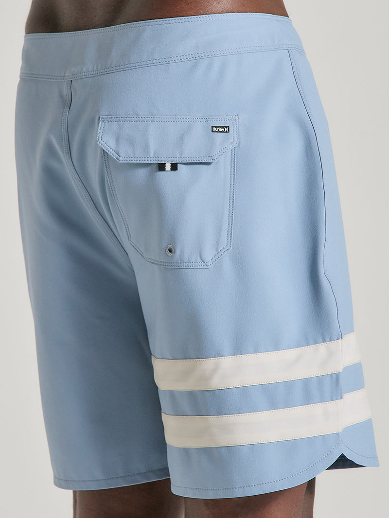 Boardshorts phantom 18 polegadas azul claro com bolso traseiro com aba, detalhe da etiqueta “Hurley X” e duas listras brancas na perna direita.