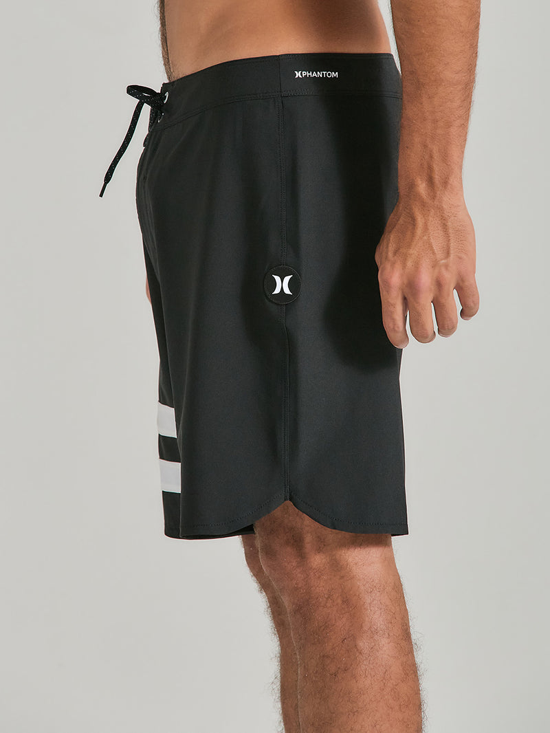 Boardshorts phantom 18 polegadas preto com ajuste por cordão na cintura, listras brancas na lateral esquerda e logo discreto na perna.