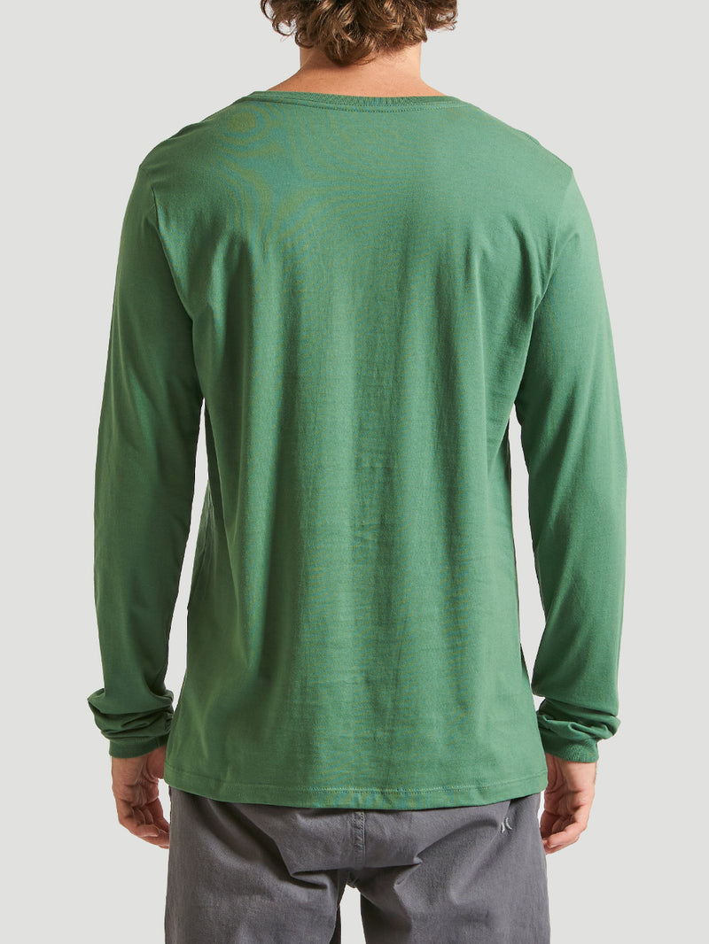 Camiseta verde militar manga longa, combinada com calça cinza. Fundo neutro em tom claro.