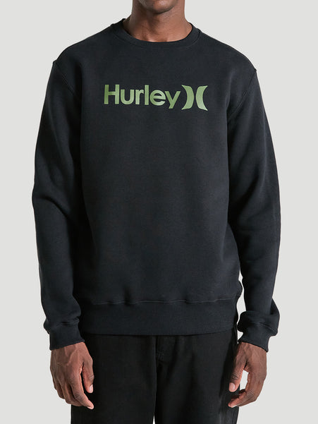 Homem vestindo um moletom careca preto felpado Hurley, com logo verde no centro, mangas longas e punhos canelados, combinado com calça preta.