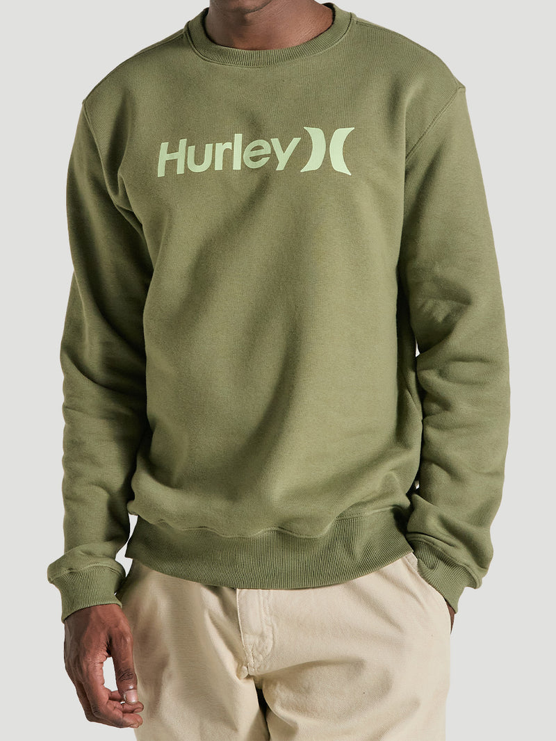 Homem vestindo um moletom careca verde militar felpado Hurley, com logo verde claro no centro, gola canelada e acabamento ajustado nos punhos e barra.