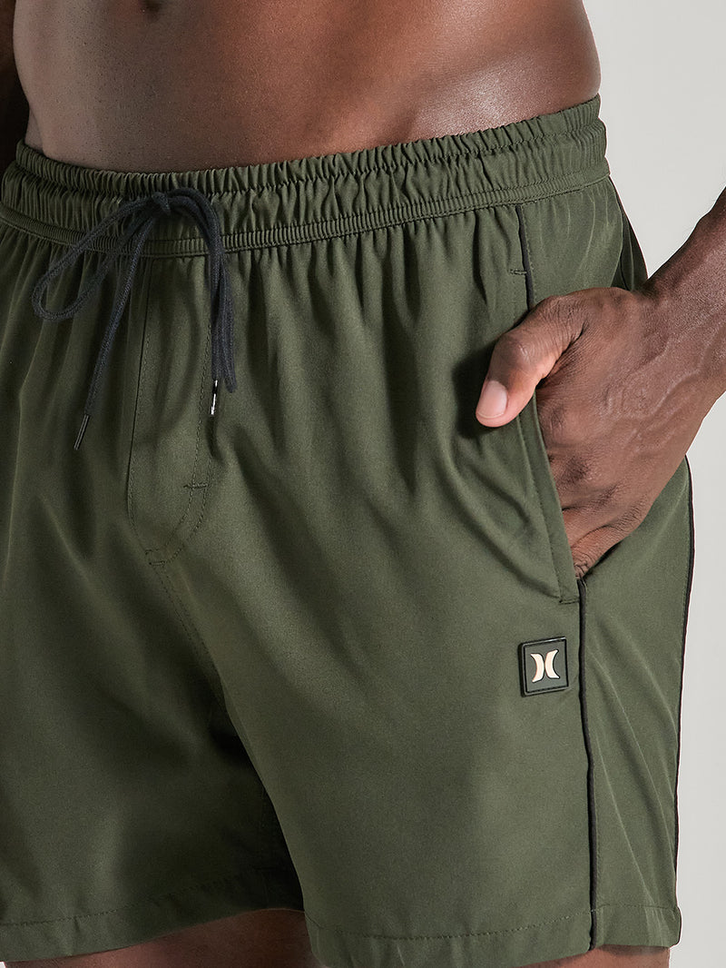 Shorts tactel verde militar 17 polegadas com cós elástico com cordão preto ajustável, bolso lateral e pequeno logo no canto da perna esquerda.