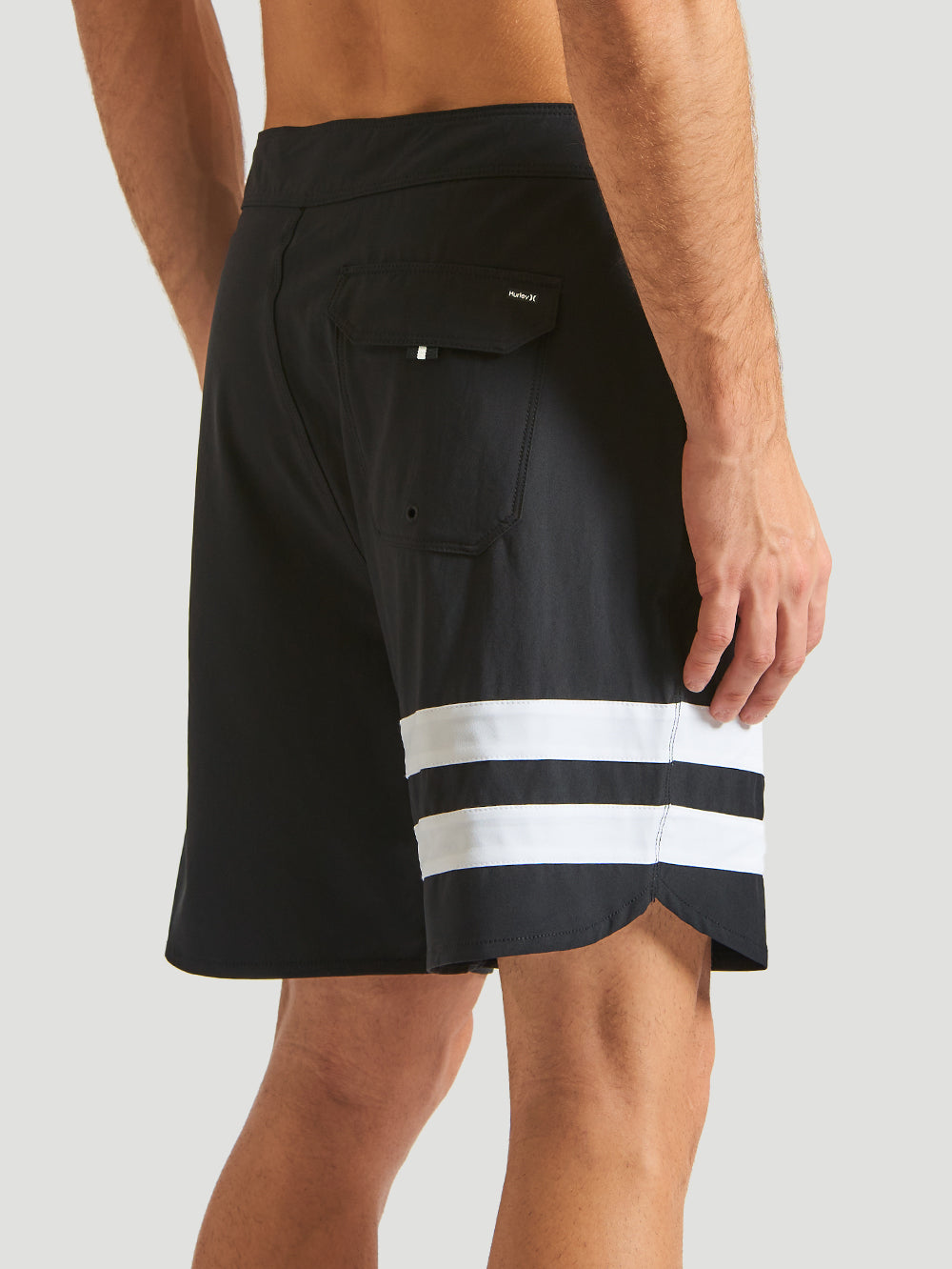 Boardshorts Phantom Hurley preto com duas listras grossas brancas na perna direita. Possui bolso traseiro com aba e design esportivo e confortável.