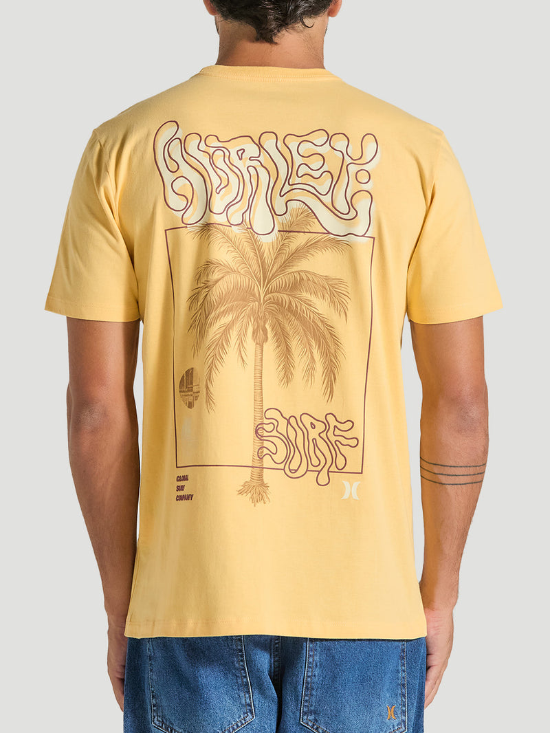 Esta camiseta amarela manga curta estampa relevo apresenta um visual descontraído com uma arte nas costas que remete ao estilo surfista. O design inclui uma palmeira centralizada e elementos gráficos que evocam uma estética tropical, com as palavras "Hurley" e "Surf" em uma fonte fluida e descontraída. 