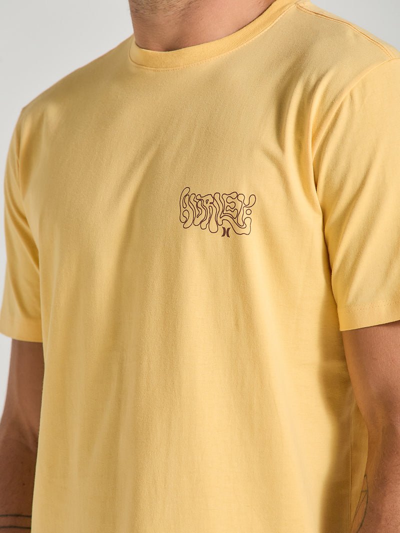 Camiseta amarela manga curta estampa relevo com design minimalista no lado esquerdo do peito. A estampa apresenta o nome "Hurley" em um estilo psicodélico e fluido, que adiciona um toque moderno e artístico à peça. 