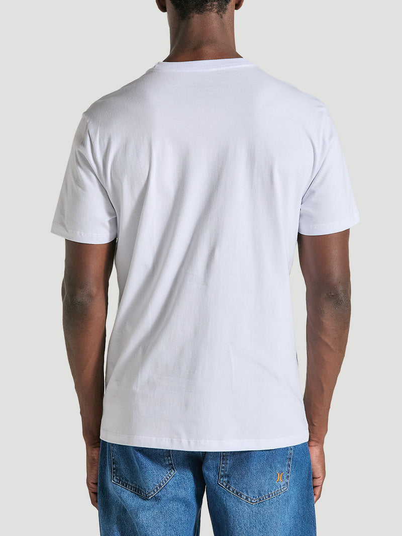 Homem veste uma camiseta branca estampa frontal manga curta de algodão, sem estampas na parte traseira, combinando com calça jeans azul. Design simples e casual.