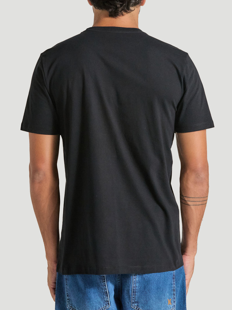Homem veste camiseta preta estampa frontal manga curta, sem elementos na parte traseira, combinada com calça jeans azul, em um estilo casual e minimalista.