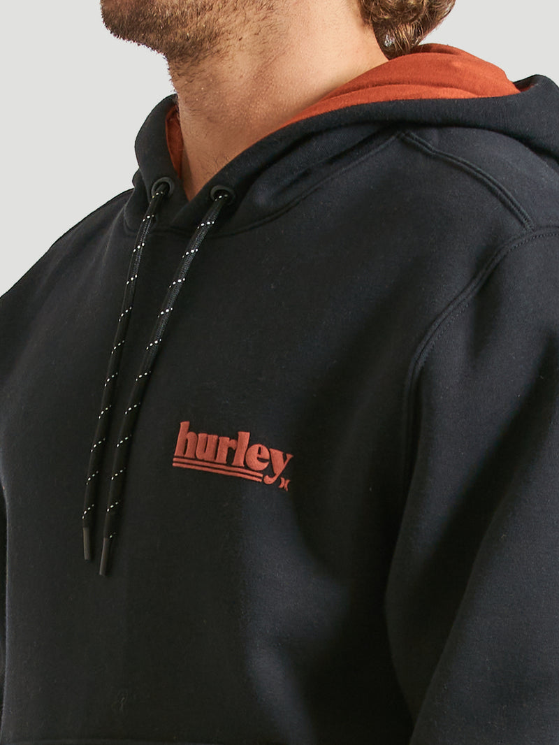 Detalhe do moletom canguru preto da Hurley, destacando o capuz forrado em tom terroso, cordões ajustáveis e logo bordado em vermelho no peito. Estilo casual e moderno.