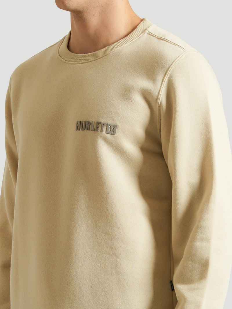 Detalhe do moletom careca areia da Hurley, com logo discreto no peito e gola canelada. Modelo confortável e estiloso, perfeito para um look casual moderno.