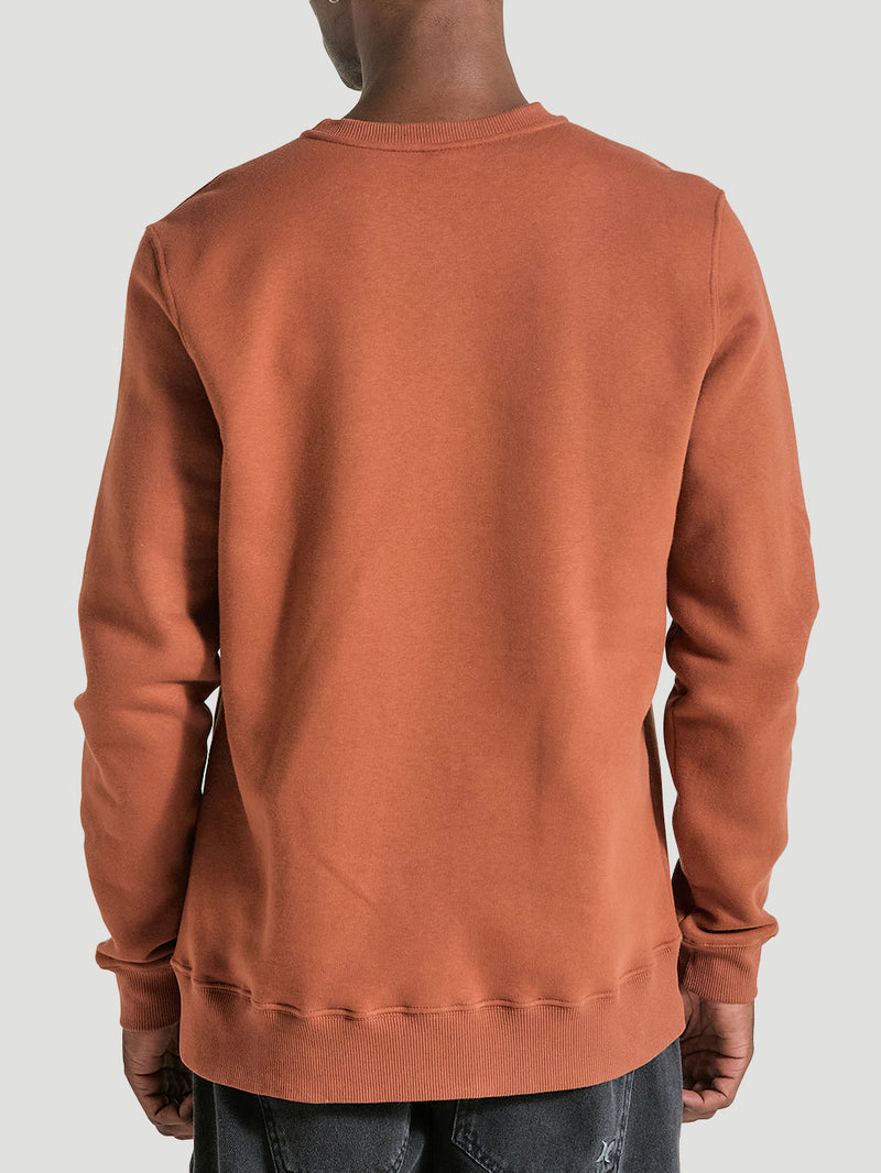 Pessoa de costas vestindo moletom careca marrom, com design simples, acabamento ajustado nos punhos e na barra e tecido com textura suave.