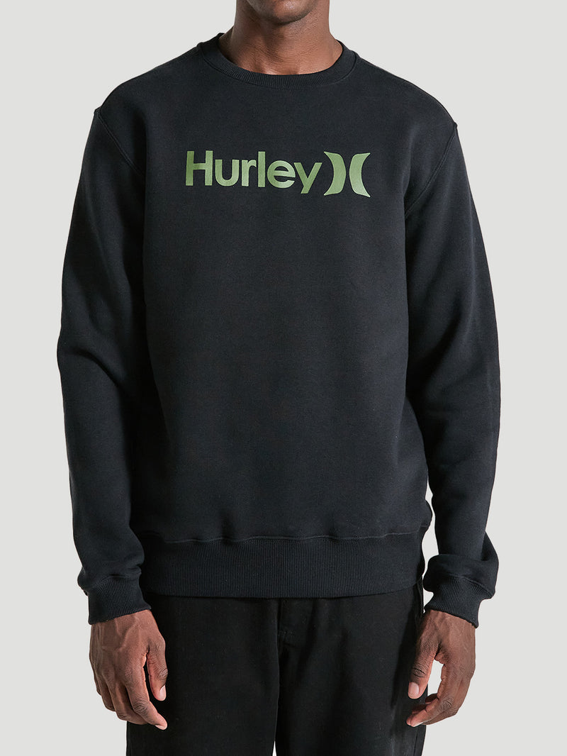 Homem vestindo um moletom careca preto felpado Hurley, com logo verde no centro, mangas longas e punhos canelados, combinado com calça preta.