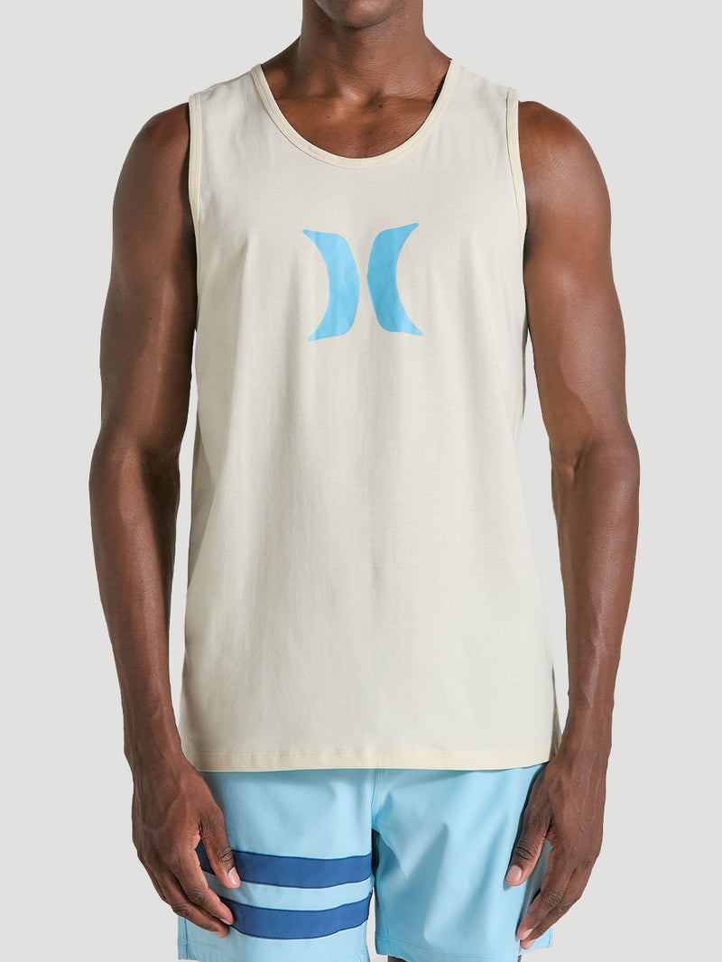 Homem vestindo regata off white de algodão com estampa azul no peito. A peça tem corte reto e é combinada com bermuda azul clara com listras.