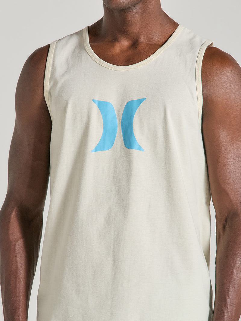 Homem vestindo regata off white de algodão, com logo azul estampado no peito. A peça possui corte reto e acabamento simples, ideal para ocasiões casuais.