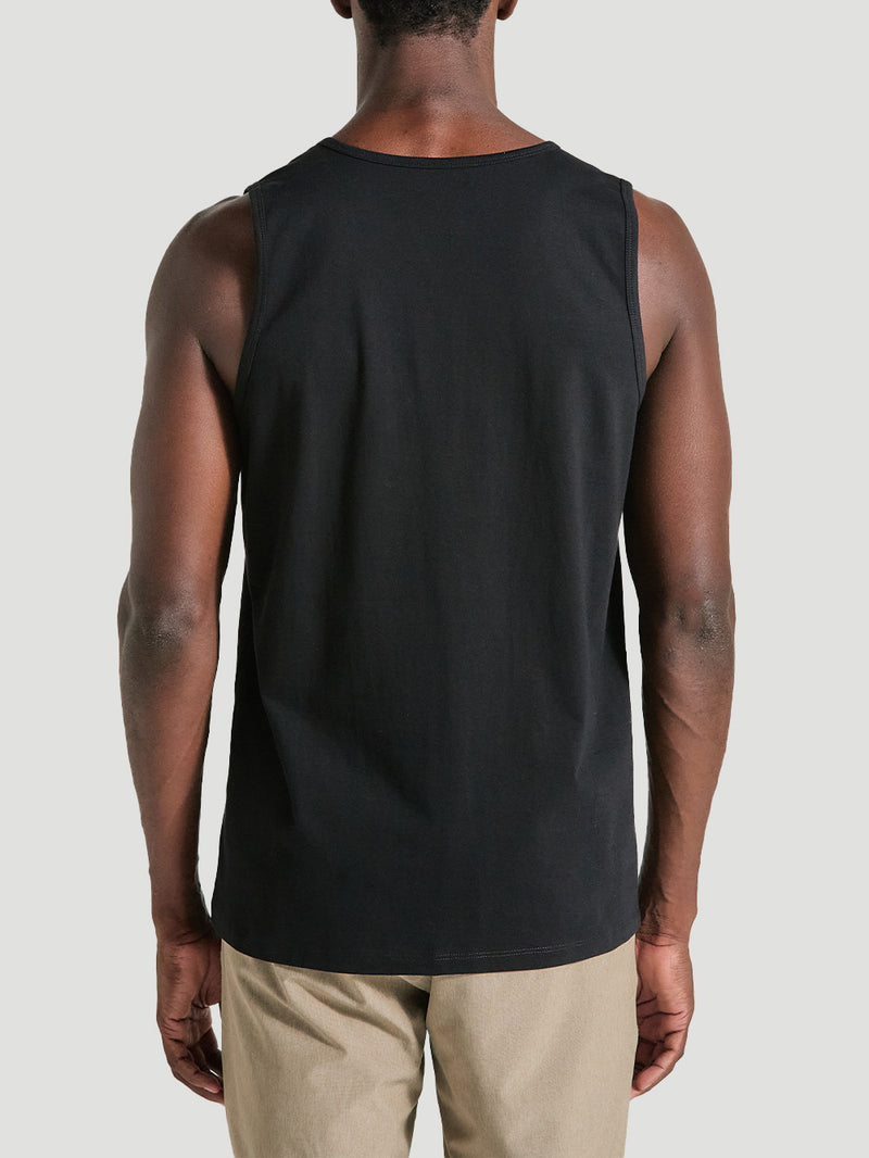 Homem de costas vestindo a regata preta de algodão simples, sem estampas visíveis, combinada com bermuda bege, criando um visual casual.