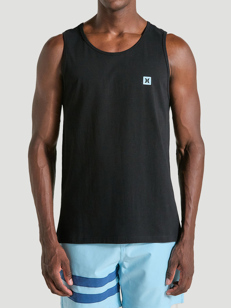 regata preta esportiva com logo discreto no peito e corte reto. A peça é combinada com bermuda azul clara com listras horizontais.