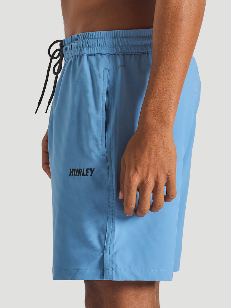 Short azul claro Hurley com cós elástico ajustável por cordão preto, bolsos laterais e tecido leve. Logo discreto da marca na perna esquerda.