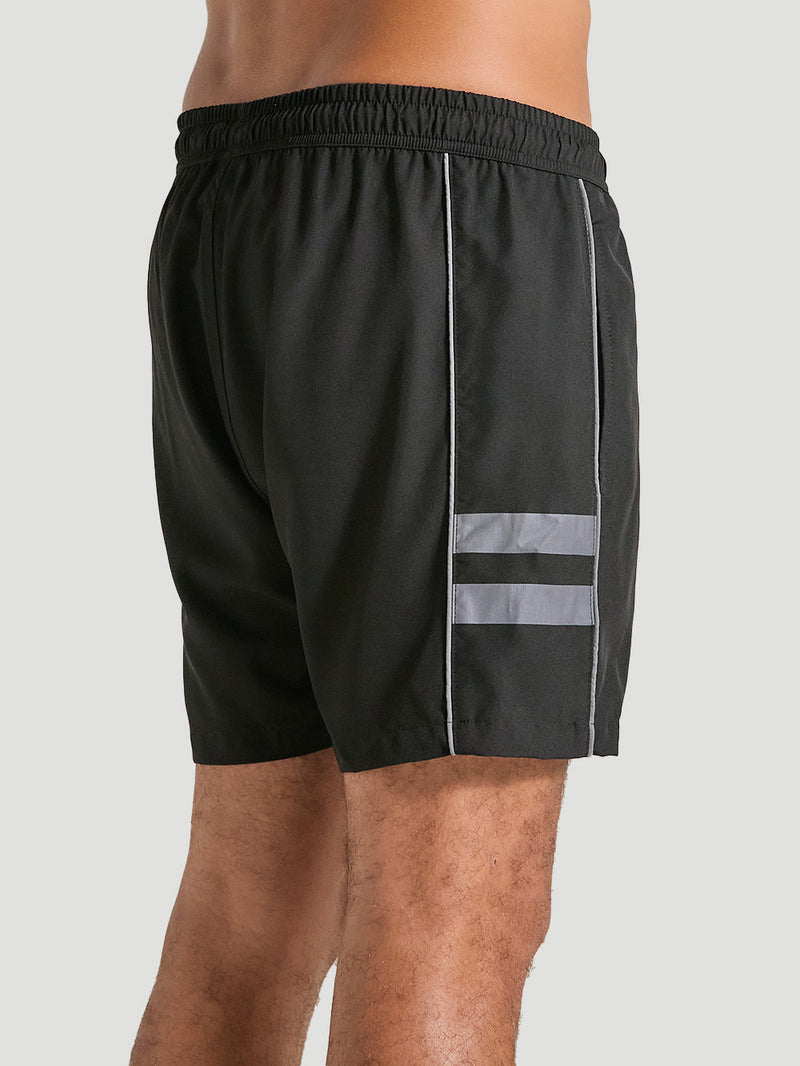 Shorts tactel preto 17 polegadas com detalhe de duas listras reflexivas na lateral, cós elástico e costura reforçada.