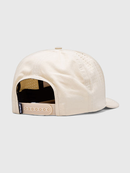 Boné bege com ajuste traseiro, laterais perfuradas para ventilação e design casual, ideal para complementar looks do dia a dia.