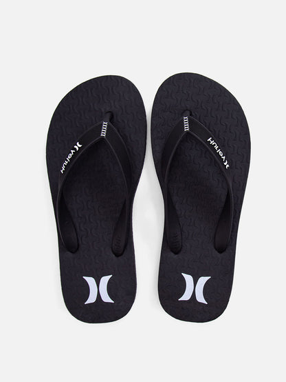Chinelo Hurley preto com tiras emborrachadas texturizadas, logo branco no solado e detalhe de costura decorativa nas tiras. Design simples e casual.