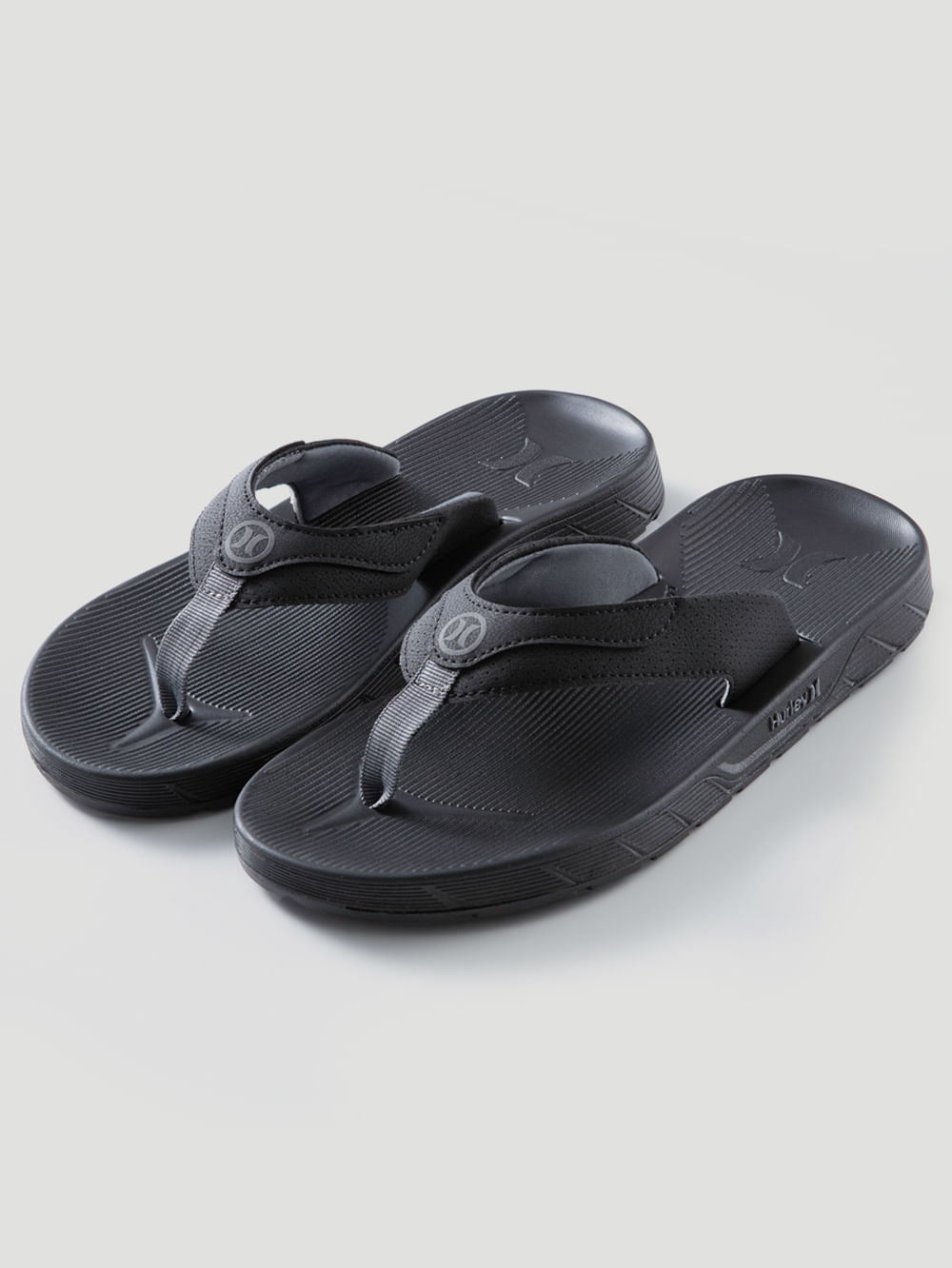 Chinelo preto Hurley com tiras grossas texturizadas, logotipo em relevo e solado anatômico antiderrapante. Design esportivo e confortável.