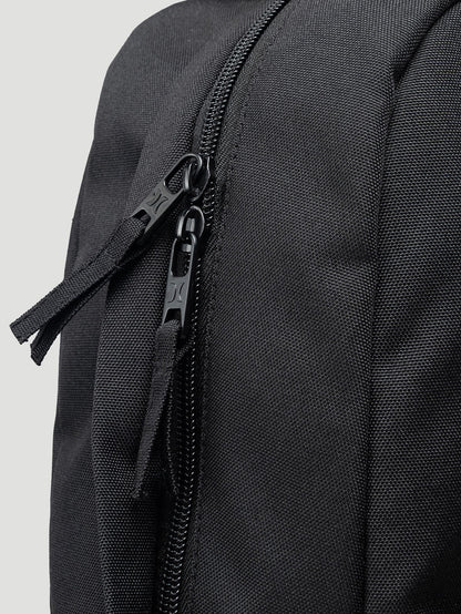 Detalhe de zíper duplo em mochila para notebook preta, com costuras reforçadas e material resistente, ideal para o dia a dia ou trabalho.